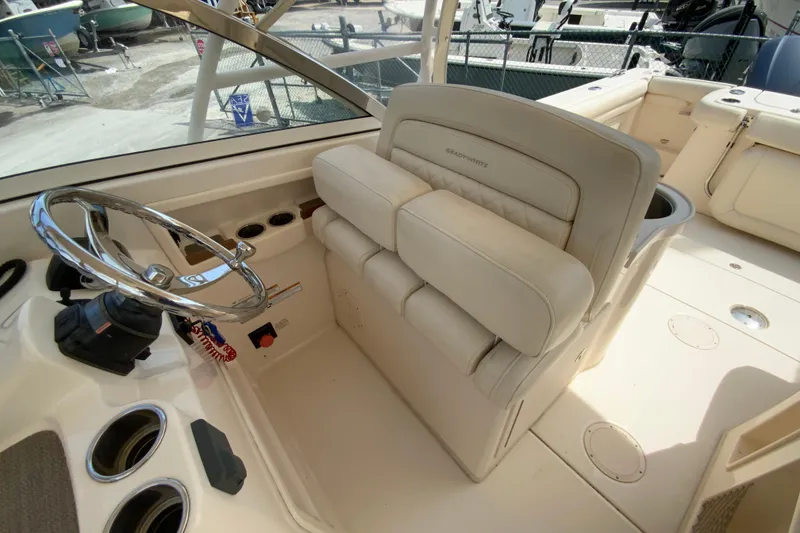 Slide: The Image of 2017 Grady-White Freedom 307 boat interior with steering wheel and beige seating. - 21