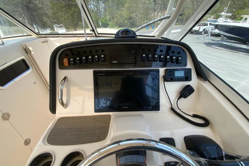 Slide: The Image of 2017 Grady-White Freedom 307 boat dashboard with navigation controls and display. - 22