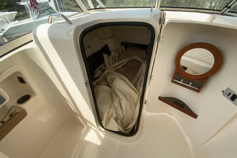 Slide: The Image of 2017 Grady-White Freedom 307 boat interior storage compartment with mirror and fabric items. - 25
