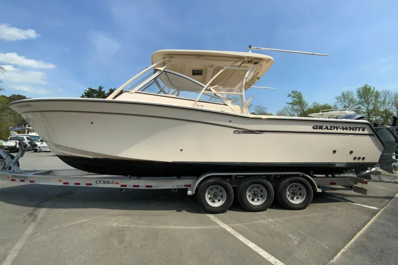 Slide: The Image of 2017 Grady-White Freedom 307 boat on trailer, parked outdoors under clear sky. - 6