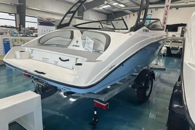 Slide: The Image of 2025 Yamaha Boats AR190 in showroom, sleek design, white and blue exterior. - 12