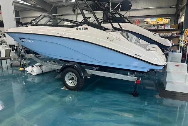Slide: The Image of 2025 Yamaha Boats AR190 in showroom, blue hull, on trailer. - 13