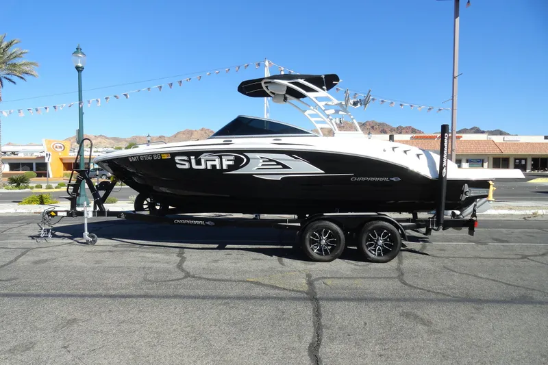 The Image of 2023 Chaparral 23 Surf boat on trailer in sunny outdoor setting. - 1