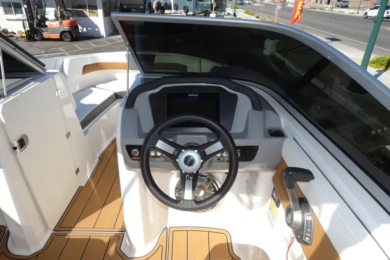 Slide: The Image of 2023 Chaparral 23 Surf boat cockpit with steering wheel and control panel. - 11