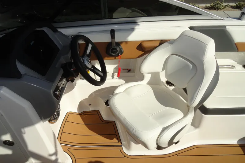 Slide: The Image of 2023 Chaparral 23 Surf boat interior with white seating and modern dashboard. - 15