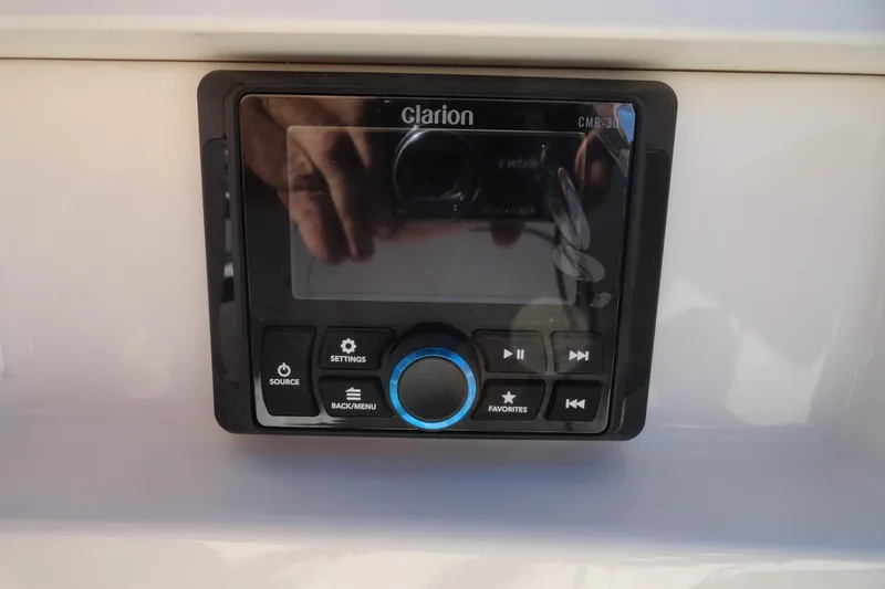 Slide: The Image of Control panel of a 2023 Chaparral 23 Surf boat featuring a Clarion audio system. - 19