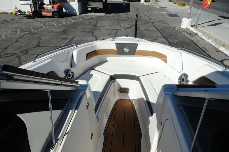 Slide: The Image of 2023 Chaparral 23 Surf boat interior with white seating and wood accents. - 20