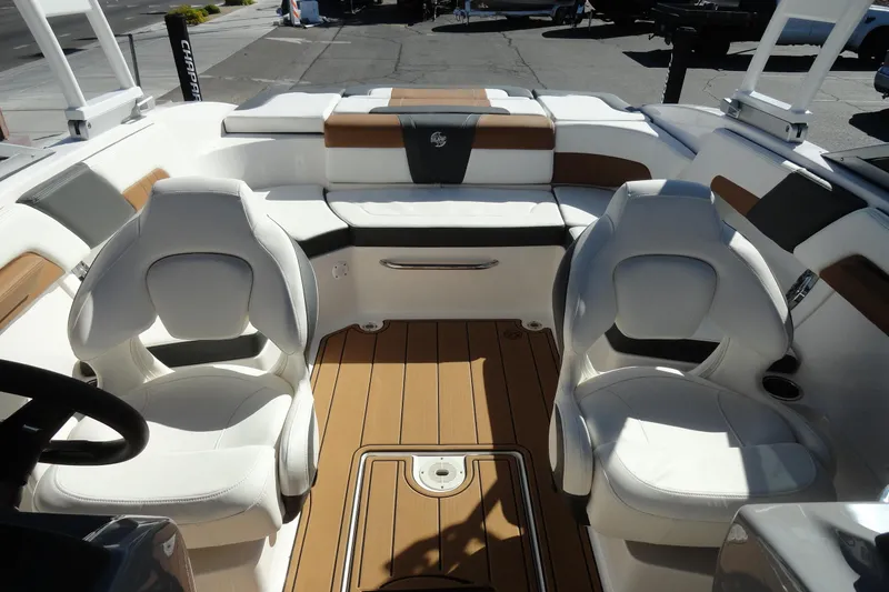 Slide: The Image of 2023 Chaparral 23 Surf boat interior with white seating and wood flooring. - 22