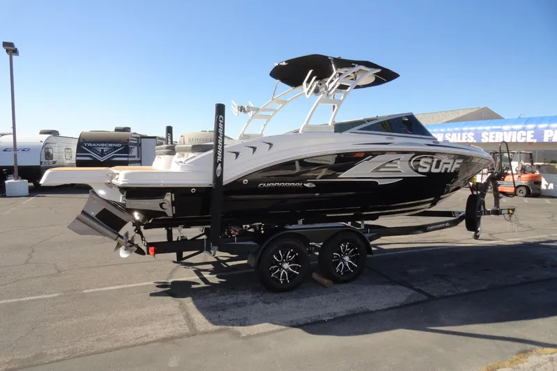 Slide: The Image of 2023 Chaparral 23 Surf boat on trailer at dealership, showcasing sleek design. - 5