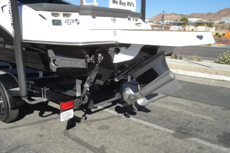 Slide: The Image of 2023 Chaparral 23 Surf boat on trailer, rear view with propeller and license plate. - 6
