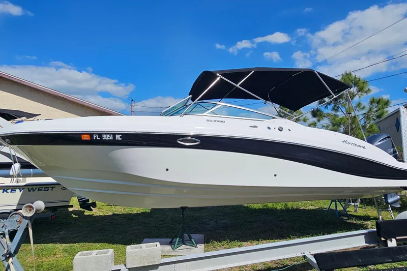Slide: The Image of 2016 Hurricane SunDeck 2690 OB boat on trailer under blue sky. - 13