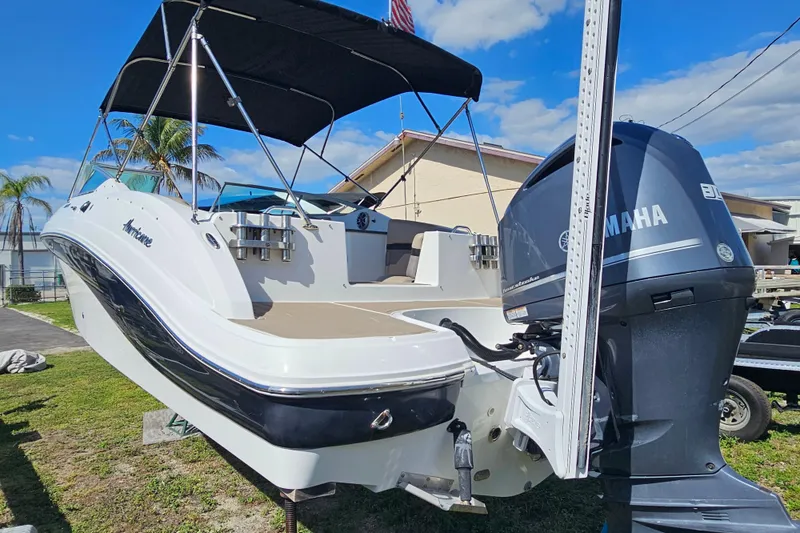 Slide: The Image of 2016 Hurricane SunDeck 2690 OB boat with Yamaha outboard motor, parked outdoors. - 16