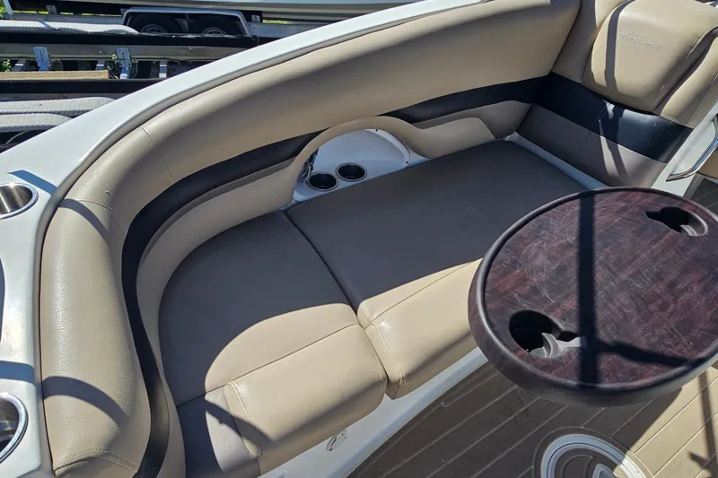 Slide: The Image of 2016 Hurricane SunDeck 2690 OB boat interior with beige seating and a round table. - 19