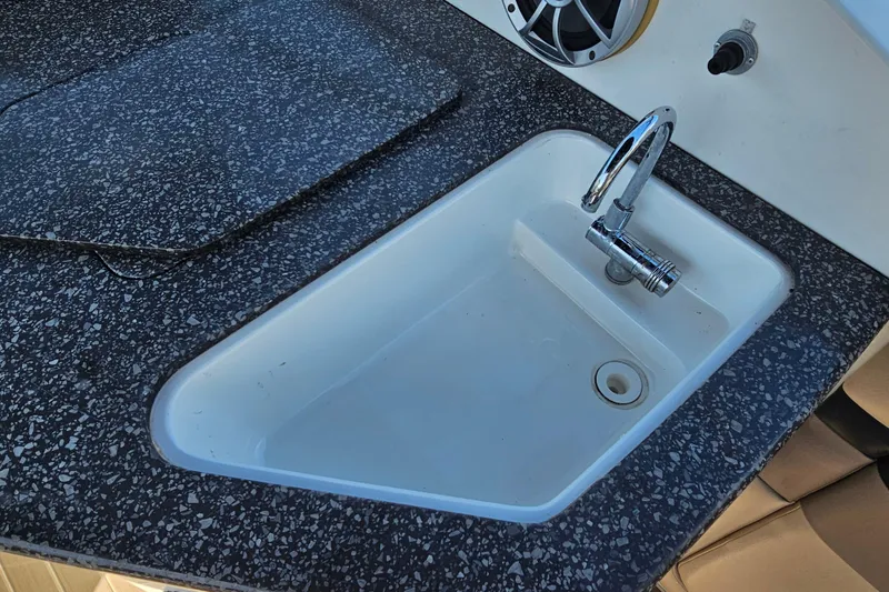 Slide: The Image of 2016 Hurricane SunDeck 2690 OB boat sink with speckled countertop and chrome faucet. - 22