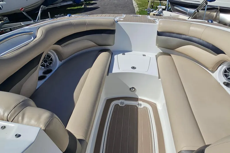 Slide: The Image of 2016 Hurricane SunDeck 2690 OB boat interior with beige seating and cup holders. - 27