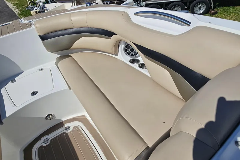 Slide: The Image of 2016 Hurricane SunDeck 2690 OB boat interior with beige and black seating, speaker, and storage compartments. - 29