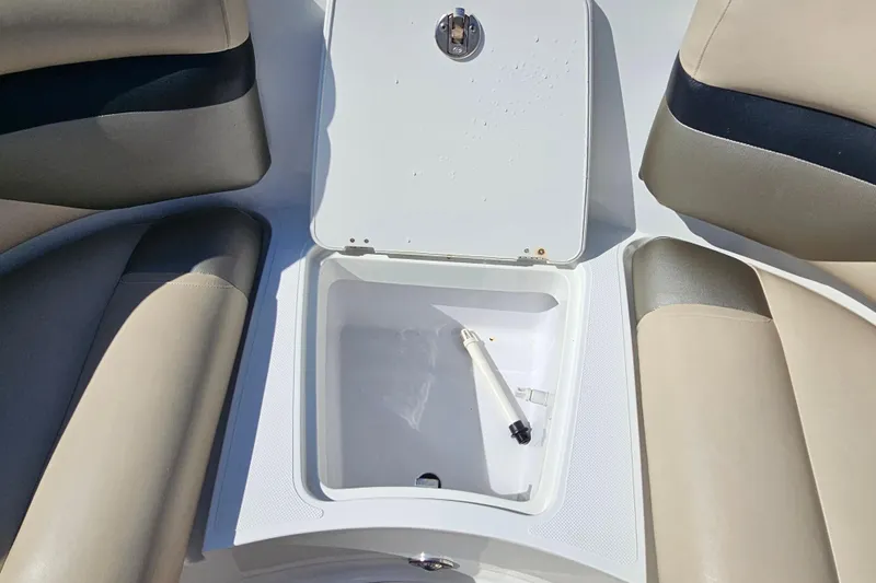 Slide: The Image of Open storage compartment on 2016 Hurricane SunDeck 2690 OB boat with beige seating. - 30