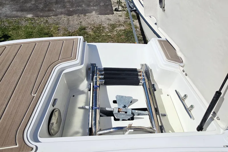 Slide: The Image of 2016 Hurricane SunDeck 2690 OB boat anchor storage compartment with wooden deck accents. - 31