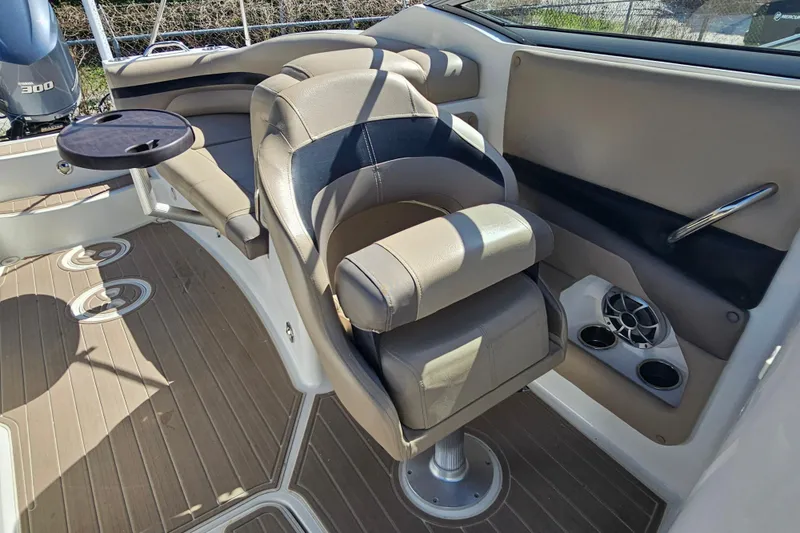 Slide: The Image of 2016 Hurricane SunDeck 2690 OB boat interior with beige seating and cup holders. - 33