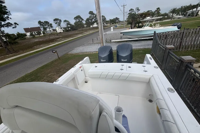 Slide: The Image of 2017 Buddy Davis 28 Center Console boat with dual engines, parked near a residential area. - 15