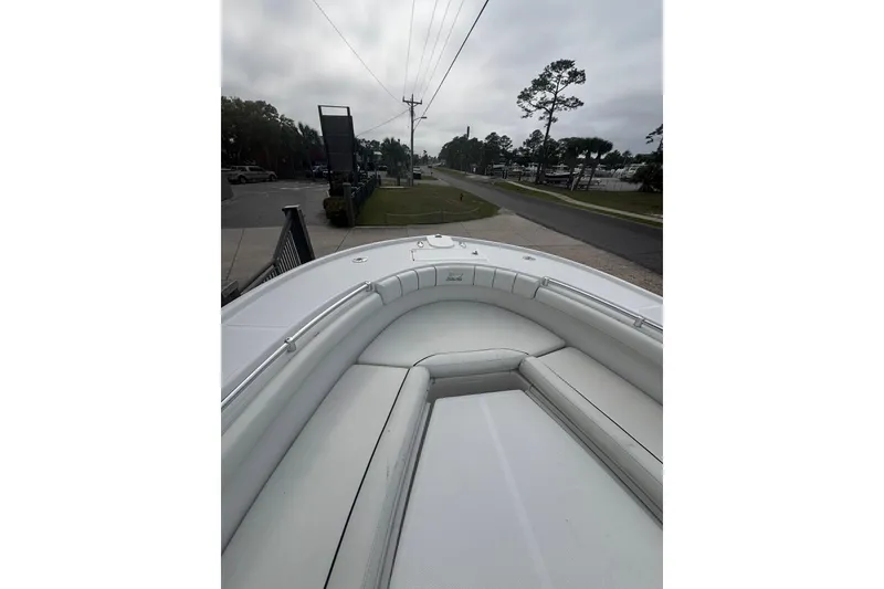 Slide: The Image of 2017 Buddy Davis 28 Center Console boat with cushioned seating, parked near a road. - 16