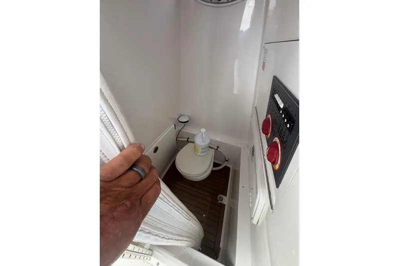 Slide: The Image of Interior of 2017 Buddy Davis 28 Center Console boat, featuring a compact bathroom area. - 19