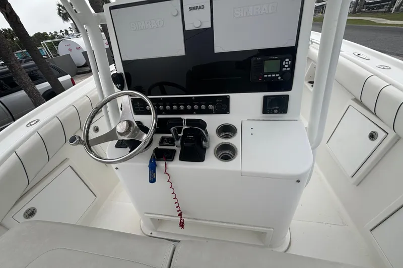 Slide: The Image of 2017 Buddy Davis 28 Center Console boat helm with steering wheel and Simrad electronics. - 7