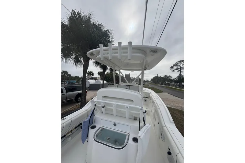 Slide: The Image of 2017 Buddy Davis 28 Center Console boat with T-top and rod holders, parked roadside. - 9