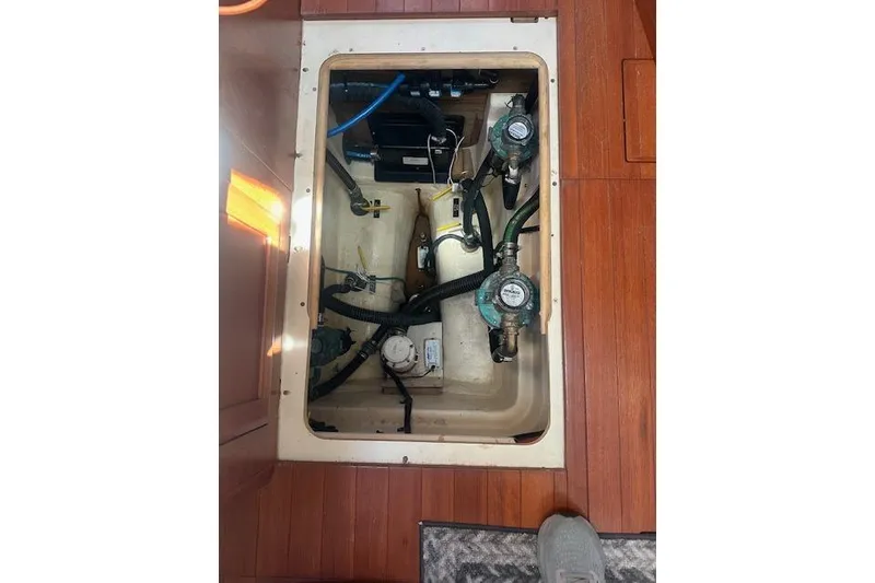 Slide: The Image of Engine compartment of 2011 Hunter Aft Cockpit 50 yacht with visible components and wooden flooring. - 16