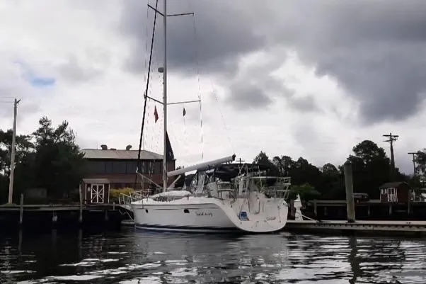 Slide: The Image of 2011 Hunter Aft Cockpit 50 sailboat docked under cloudy skies. - 2