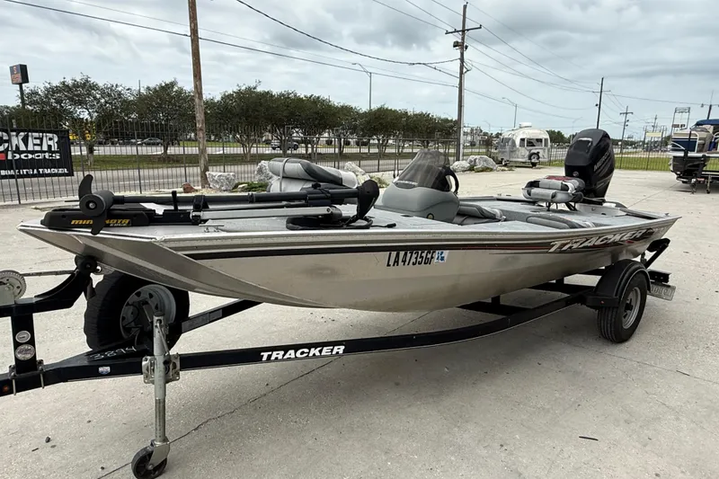 Slide: The Image of 2016 Tracker Pro 170 boat on trailer, parked outdoors, featuring a sleek design and motor. - 3