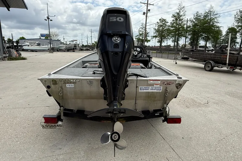 Slide: The Image of 2016 Tracker Pro 170 boat with outboard motor, parked on a trailer in a marina. - 5
