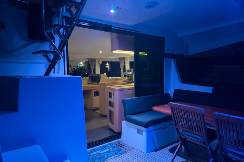 Slide: The Image of Interior view of a 2018 Lagoon 42 catamaran with blue ambient lighting. - 10