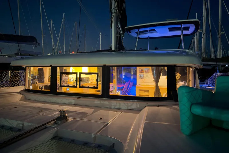 Slide: The Image of 2018 Lagoon 42 catamaran illuminated at night in a marina setting. - 13