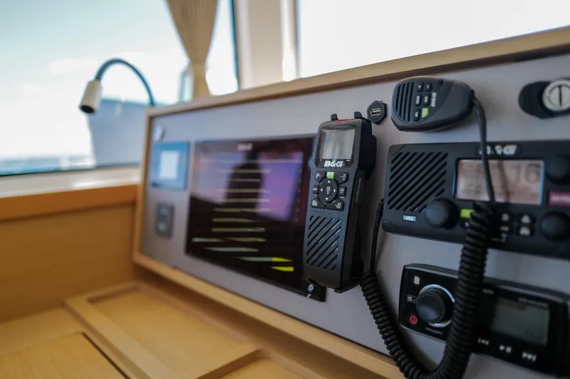 Slide: The Image of Control panel of a 2018 Lagoon 42 catamaran with navigation equipment and radio. - 18