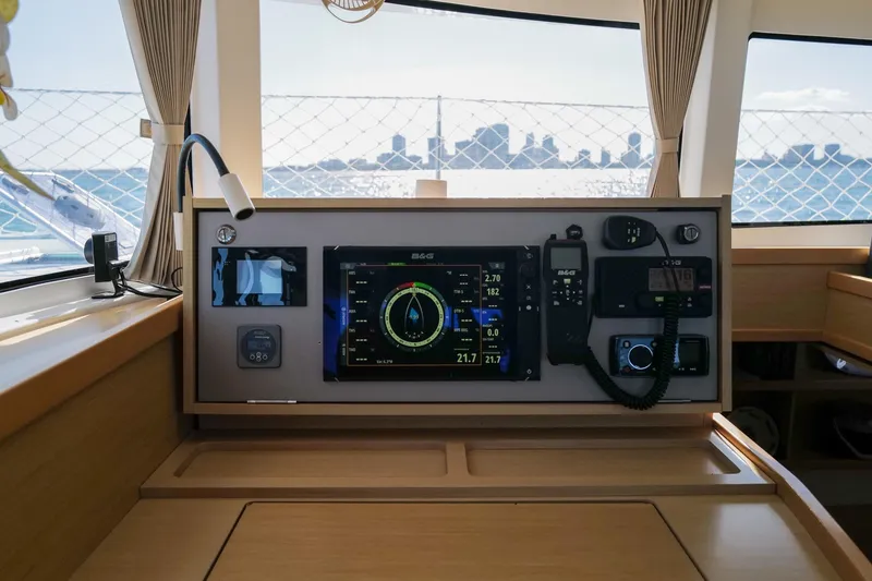 Slide: The Image of Interior view of a 2018 Lagoon 42 yacht's navigation panel with city skyline in background. - 19