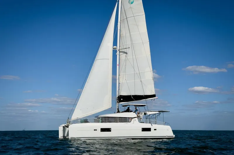 Slide: The Image of 2018 Lagoon 42 catamaran sailing on open sea under clear blue sky. - 2