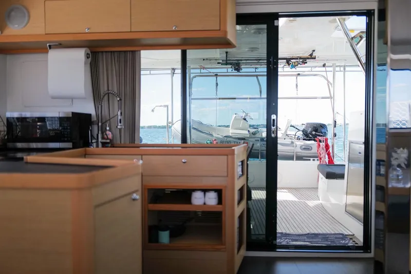 Slide: The Image of Interior view of 2018 Lagoon 42 catamaran kitchen with ocean view through sliding glass door. - 20