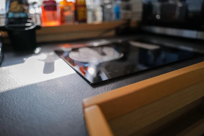 Slide: The Image of Modern kitchen interior on a 2018 Lagoon 42 yacht, featuring a sleek stovetop. - 22