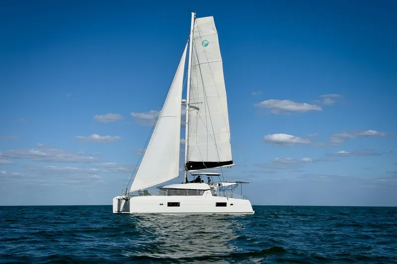 Slide: The Image of 2018 Lagoon 42 catamaran sailing on open sea under clear blue sky. - 3