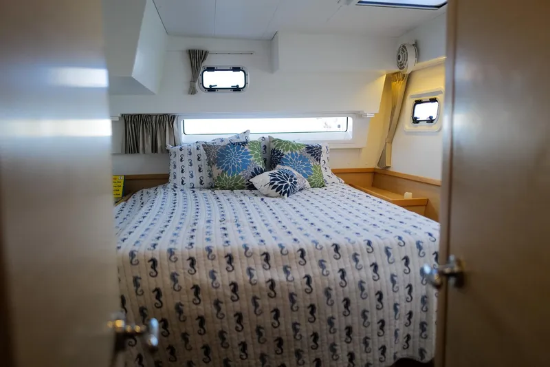 Slide: The Image of Cozy bedroom in 2018 Lagoon 42 yacht with nautical-themed bedding and decorative pillows. - 46