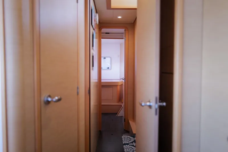Slide: The Image of Interior hallway of a 2018 Lagoon 42 catamaran, featuring wooden doors and modern design. - 49
