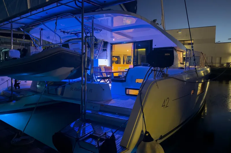 Slide: The Image of 2018 Lagoon 42 catamaran docked at night with blue ambient lighting. - 7
