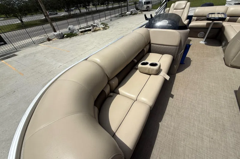 Slide: The Image of 2021 Sun Tracker Party Barge 20 DLX with beige seating and cup holders. - 12