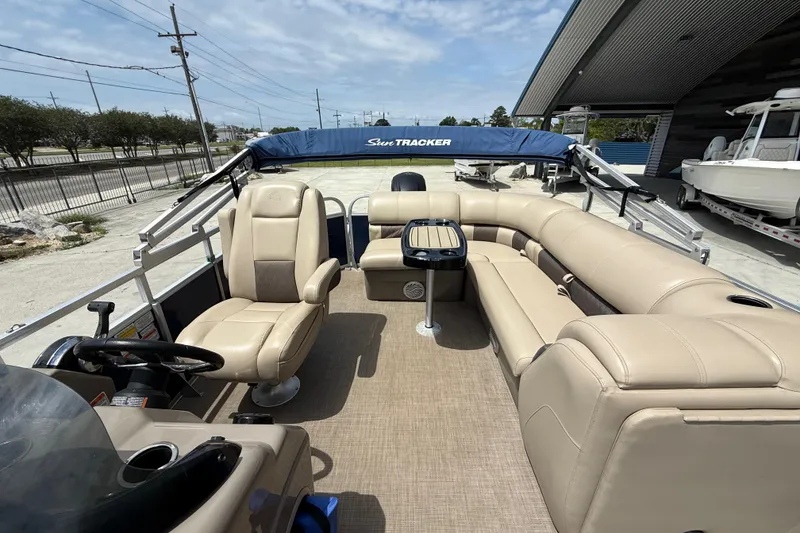 Slide: The Image of 2021 Sun Tracker Party Barge 20 DLX with beige seating and canopy, docked outdoors. - 8