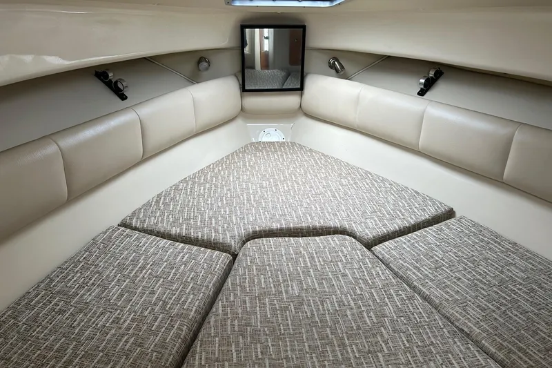 Slide: The Image of 2011 Robalo R265 Walkaround cabin interior with cushioned seating and neutral tones. - 13