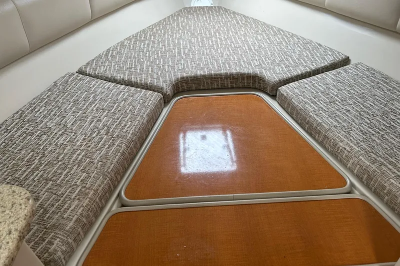 Slide: The Image of 2011 Robalo R265 Walkaround cabin interior with cushioned seating and wooden flooring. - 18