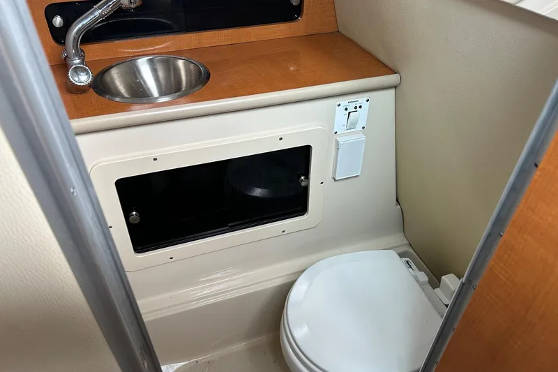 Slide: The Image of 2011 Robalo R265 Walkaround boat bathroom with sink and toilet. - 19