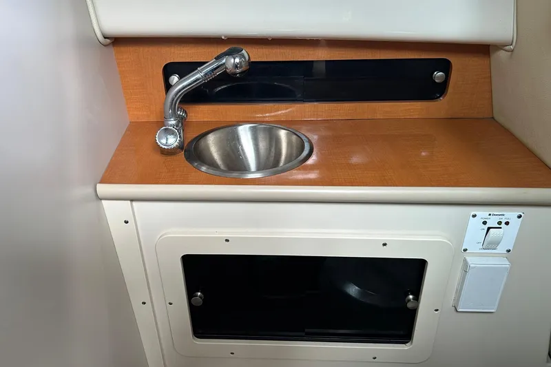 Slide: The Image of 2011 Robalo R265 Walkaround boat interior with sink and storage compartment. - 20