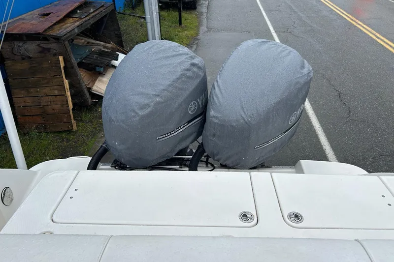 Slide: The Image of 2011 Robalo R265 Walkaround with covered outboard motors on a rainy day. - 4